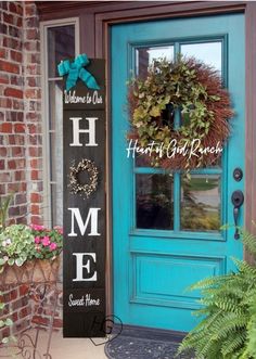 a blue front door with a sign that says home and wreaths on the side