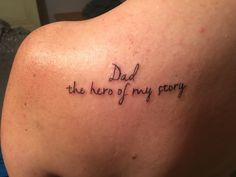 a tattoo saying dad the hero of my party on someone's upper back shoulder