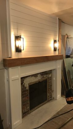 a fire place sitting in the middle of a living room next to a wall mounted tv