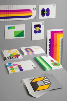 an assortment of colorful papers and stickers on top of a gray surface with various colors