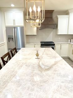 a kitchen with an island, stove and refrigerator in the middle of it's countertop