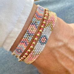 a close up of a person's arm wearing two bracelets with beads on it