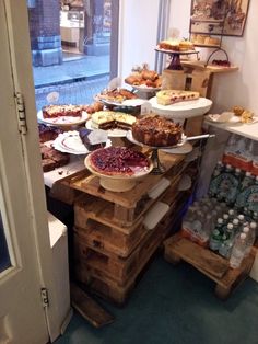 a table filled with lots of pies and pastries on top of wooden pallets