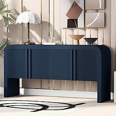 a blue console table in front of a wall with art on it