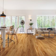 a living room filled with furniture and lots of windows next to a wooden floored floor