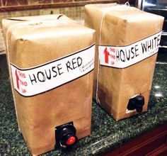 two brown paper bags sitting on top of a counter next to each other with red and white labels