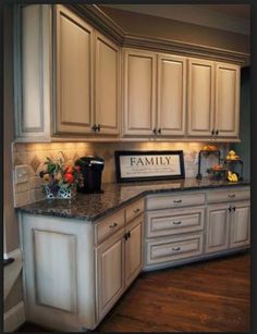 a large kitchen with white cabinets and granite counter tops, along with hardwood floorsing