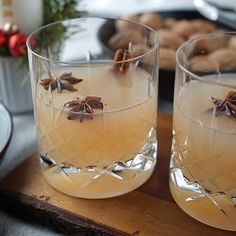 two glasses filled with liquid sitting on top of a wooden tray