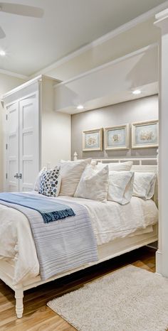 a white bed sitting inside of a bedroom on top of a hard wood floor next to a doorway