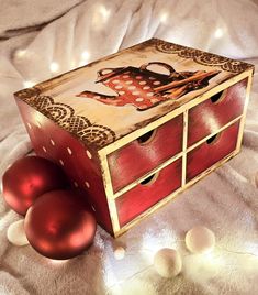 two red eggs sitting on top of a bed next to a wooden box with an octopus painted on it