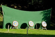 four chairs with arrows on them in front of a green tarp