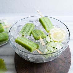 a bowl filled with pickles and cucumbers on top of ice cubes