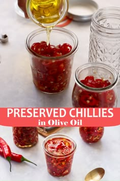 jars filled with preserves and spoons on top of a table