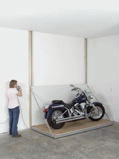 a woman standing next to a motorcycle in a room with no one on the bike