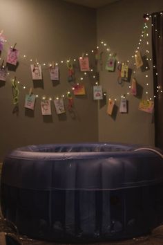 an inflatable bathtub is surrounded by post it notes and string lights on the wall