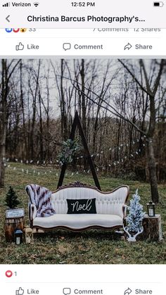 a couch sitting on top of a lush green field next to a wooden post sign