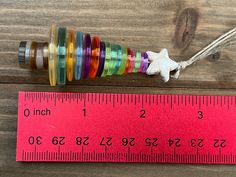 the measuring tape is next to an assortment of colored spools on a wooden table