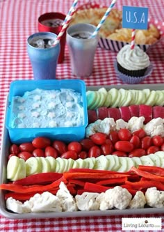 a tray filled with food on top of a red and white checkered table cloth