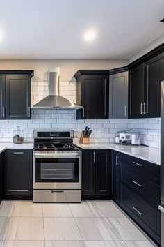 a kitchen with black cabinets and stainless steel appliances