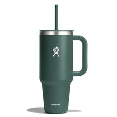 a green tumbler cup with a handle and a skull on the side, in front of a white background