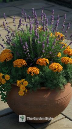 a potted planter filled with lots of yellow and purple flowers sitting on top of a patio