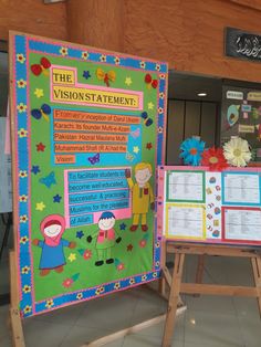 a bulletin board with information about the vision statement on it and two children standing next to it