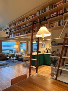 a living room filled with lots of furniture and bookshelves next to a window