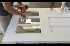 a man is sanding up the top of a kitchen counter