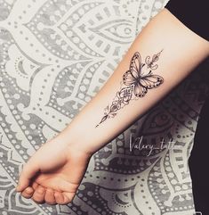 a woman's arm with a butterfly tattoo on it