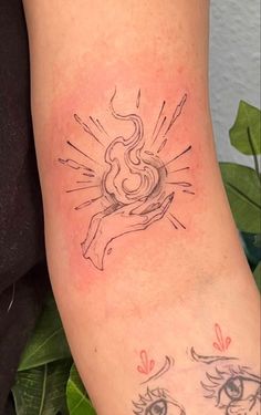 a woman's arm with tattoos on it and an image of the sun behind her