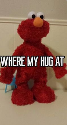 a red stuffed animal with the words where my hug at is in front of it