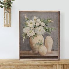 a painting of flowers in a vase on a mantle