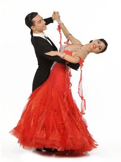 a man and woman dance together in an artistic pose, dressed in tuxedos