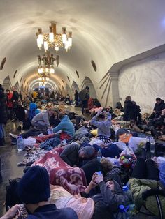 many people are sleeping on the floor in an underground tunnel