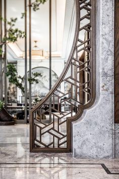 an art deco style mirror on the wall in front of a marble and metal staircase