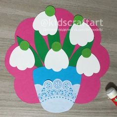 a paper cut out of a vase with flowers in it on a table next to thread spools