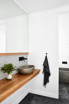 a bathroom with black and white tiles on the walls, wood countertop and sink