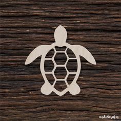 a wooden cutout of a turtle on top of a wood planked surface with the word