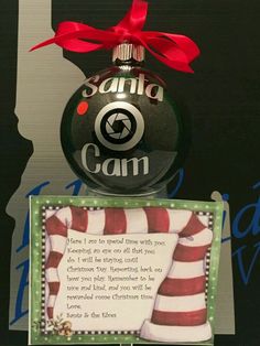 a christmas ornament that is on top of a card with a red ribbon