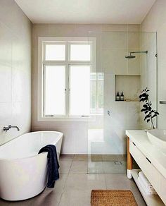 a white bath tub sitting next to a window in a bathroom