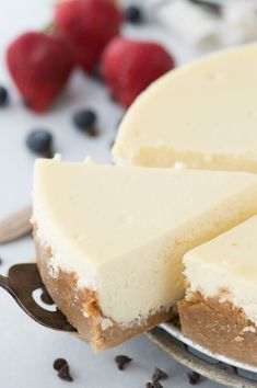 a cheesecake on a plate with berries around it