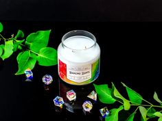 a candle sitting on top of a table next to green leaves