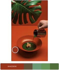 a person pouring green liquid into a bowl with food on the table next to it