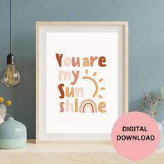 a poster with the words you are my sun shine on it and a vase next to it