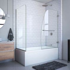 a white tiled bathroom with a walk in shower next to a bathtub and sink