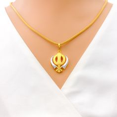 This tasteful Khanda pendant, made from 22k gold and weighing 3.8 grams, showcases an elegant dual-tone design with a primary yellow gold finish. Measuring 1.25 inches in length, it represents a blend of spiritual significance and contemporary style, embodying the essence of Sikh courage and remembrance. Ideal for those who appreciate symbolic jewelry with modern aesthetics, this dual-tone Khanda pendant is a meaningful addition to any collection, offering a touch of grace and tradition. PRODUCT DETAILS Gold Purity(karat): 22k Gold Weight(grams): 3.8 Item Finish: Yellow Gold Pendant Length: 1.25" Chain: Not Included Gold Dual-tone Jewelry For Puja, White 22k Gold Temple Necklace As Gift, White 22k Gold Temple Necklace Gift, Dual-tone Gold Temple Necklace As Gift, Dual-tone Pendant Temple Necklace As Gift, Dual-tone Pendant Temple Necklace For Gifting, Dual-tone Yellow Gold Temple Jewelry Necklace, Gold Dual-tone Temple Necklace For Puja, Dual-tone Gold Temple Necklace For Diwali