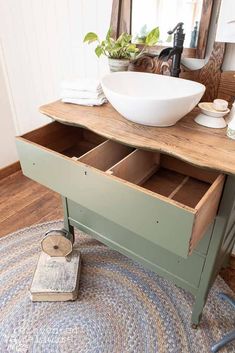 a bathroom with a sink, mirror and drawers in the middle of the floor next to a rug