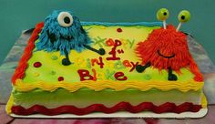 there is a birthday cake with two monsters on it