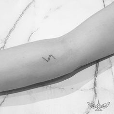 a black and white photo of a person's arm with the letter n on it