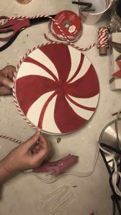 someone is making a candy cane decoration on the table